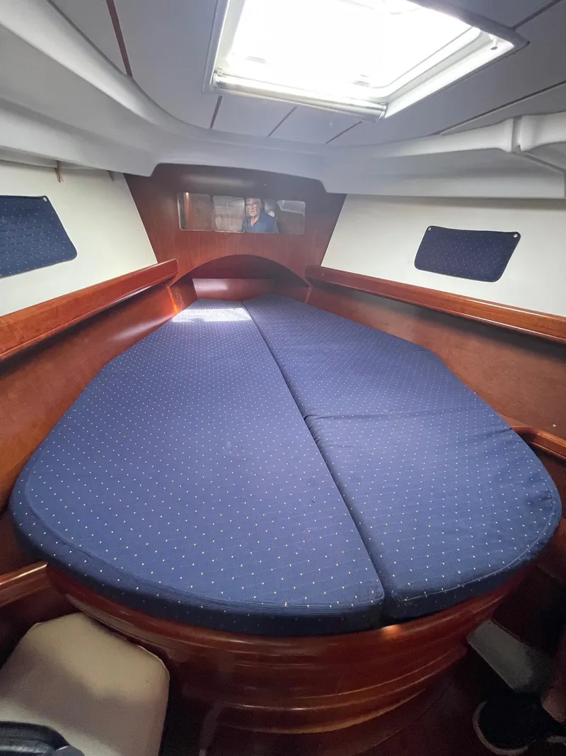 Slide: The Image of Interior cabin of 2003 Beneteau 423 sailboat with blue cushioned bed. - 16