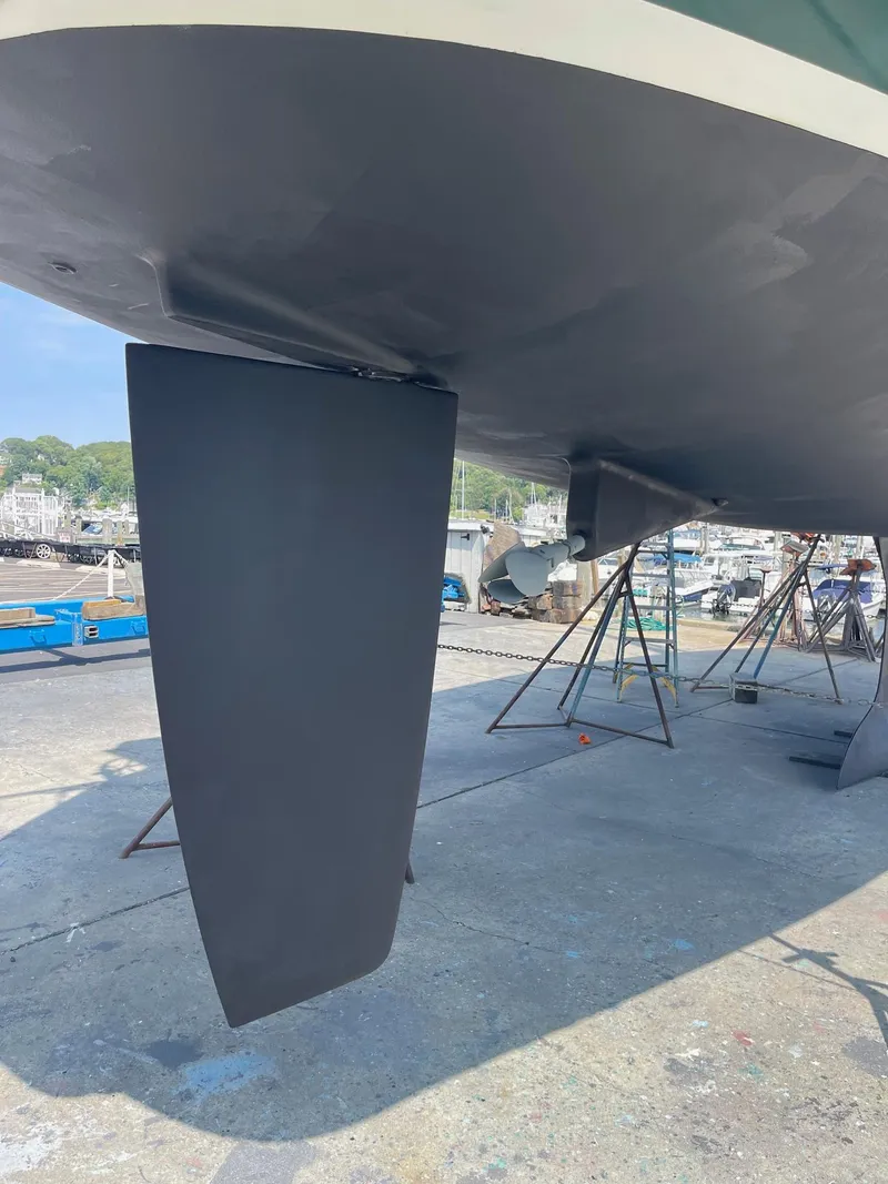 Slide: The Image of Bottom view of a 2003 Beneteau 423 sailboat on dry dock, showcasing its keel and rudder. - 20