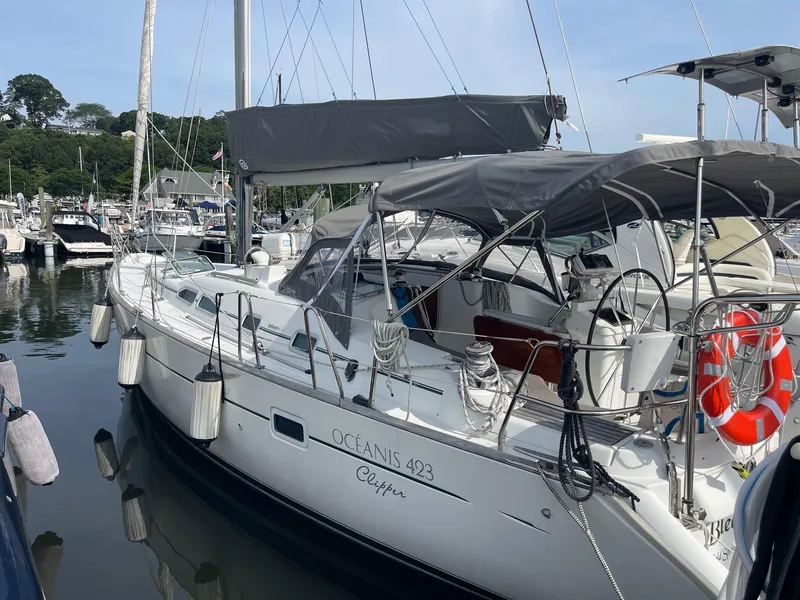 Slide: The Image of 2003 Beneteau 423 sailboat docked in a marina, featuring a sleek design and canopy. - 3