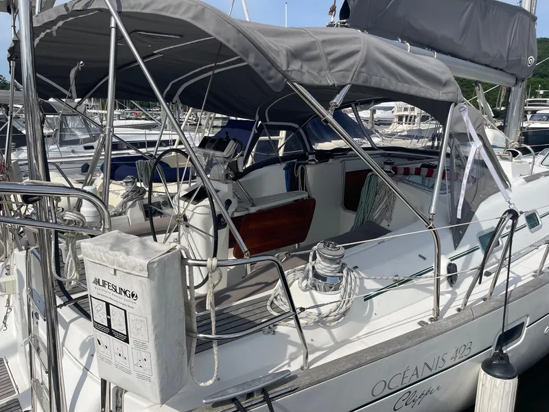 Slide: The Image of 2003 Beneteau 423 sailboat docked, featuring a covered cockpit and lifebuoy equipment. - 4