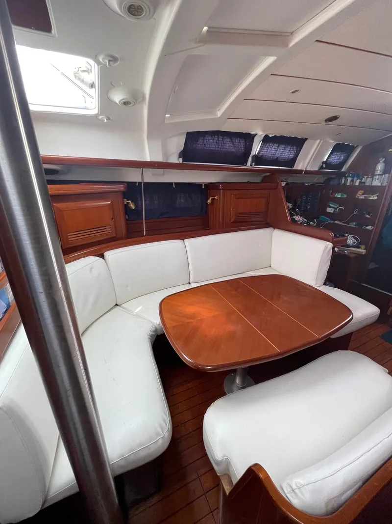 Slide: The Image of Interior of 2003 Beneteau 423 yacht with white seating and wooden table. - 8
