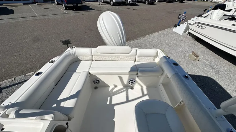 Slide: The Image of 2026 Key West 239 DFS boat interior with white seating and speakers, parked outdoors. - 10