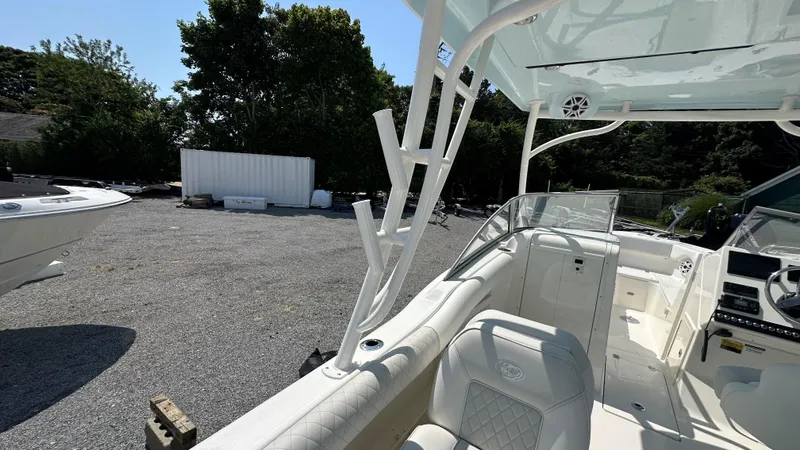 Slide: The Image of 2026 Key West 239 DFS boat interior with seating and console, parked outdoors. - 17