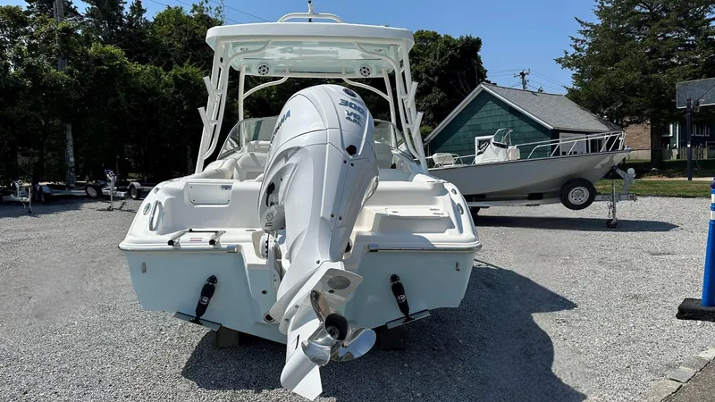 Slide: The Image of 2026 Key West 239 DFS boat with powerful outboard motor, parked on gravel lot. - 2