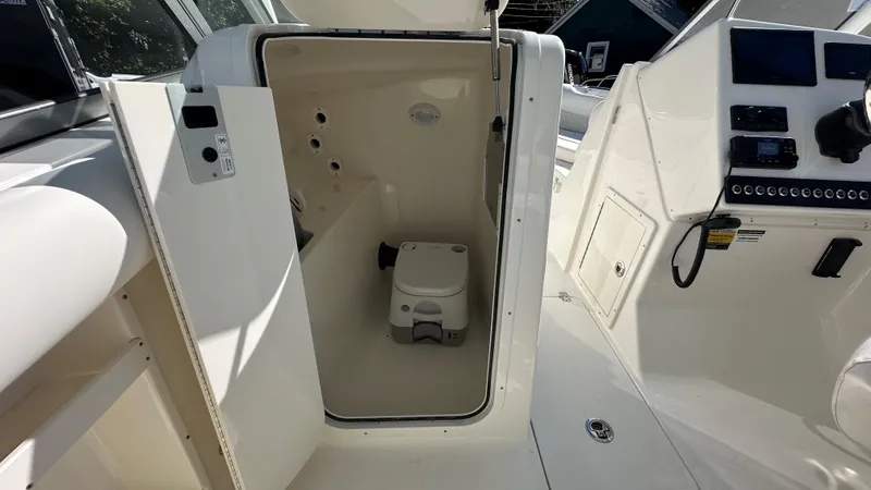 Slide: The Image of Interior view of 2026 Key West 239 DFS boat with compact marine toilet. - 25