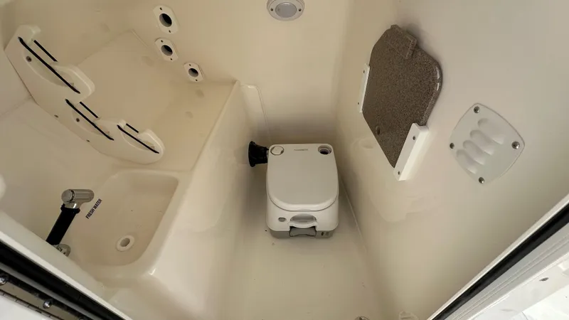 Slide: The Image of Interior of 2026 Key West 239 DFS boat with compact toilet and freshwater sink. - 26
