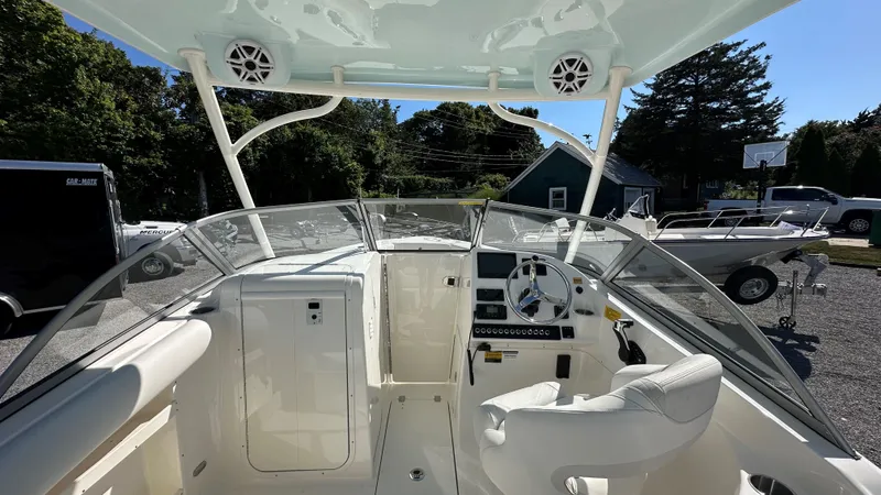 Slide: The Image of 2026 Key West 239 DFS boat interior with steering wheel and dashboard, parked outdoors. - 27