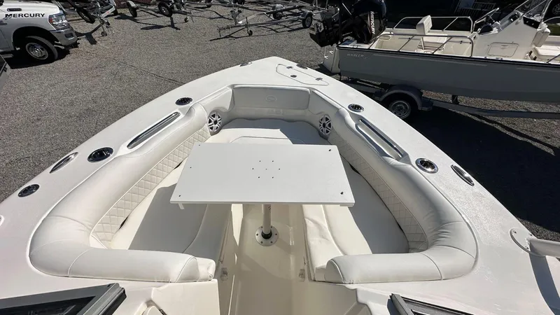 Slide: The Image of 2026 Key West 239 DFS boat with spacious seating and table, parked on gravel. - 39