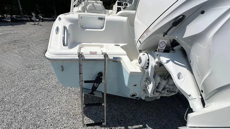 Slide: The Image of 2026 Key West 239 DFS boat stern with ladder on gravel surface. - 5