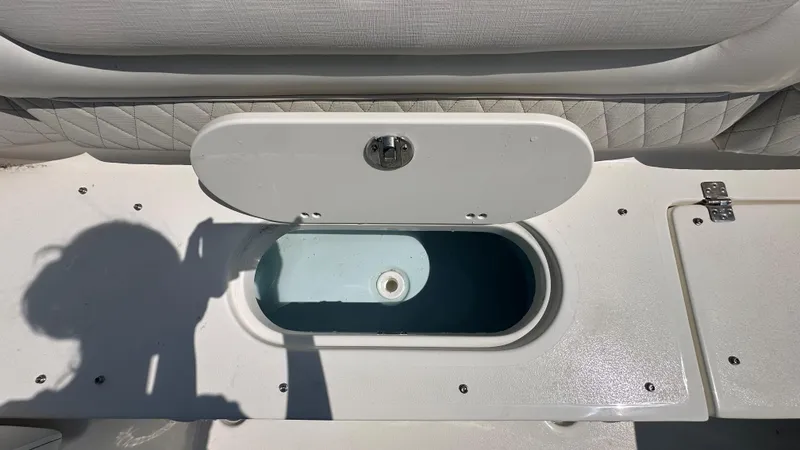 Slide: The Image of Open storage compartment on 2026 Key West 239 DFS boat, featuring quilted seating. - 9