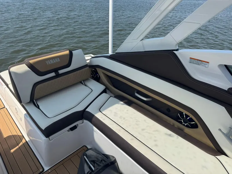 Slide: The Image of 2022 Yamaha Boats 275SD interior with luxurious seating and water view. - 11