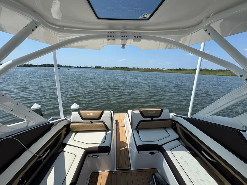 Slide: The Image of 2022 Yamaha Boats 275SD interior with water view, featuring luxurious seating and sleek design. - 16
