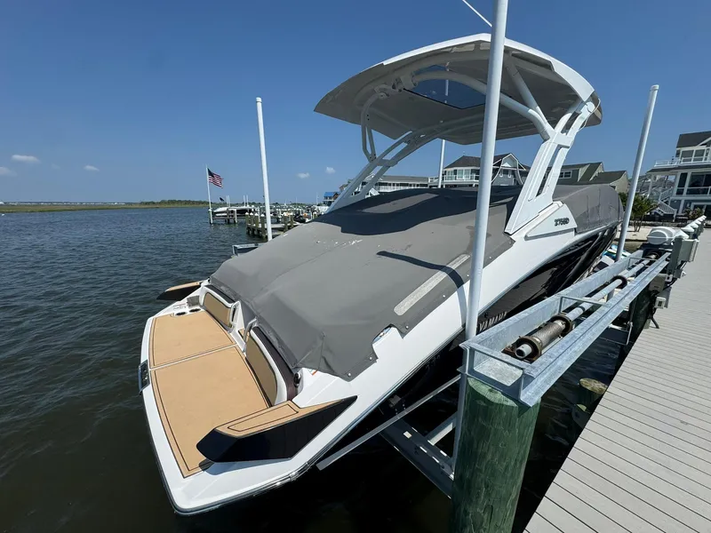 Slide: The Image of 2022 Yamaha Boats 275SD docked, covered, with clear blue sky and waterfront view. - 19