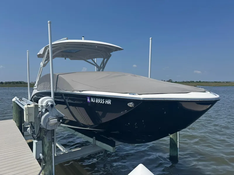 Slide: The Image of 2022 Yamaha Boats 275SD docked, covered, and elevated on a lift by the water. - 20
