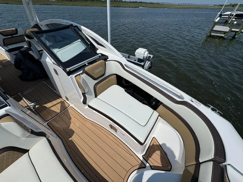 Slide: The Image of 2022 Yamaha Boats 275SD interior with luxurious seating and sleek design on the water. - 8