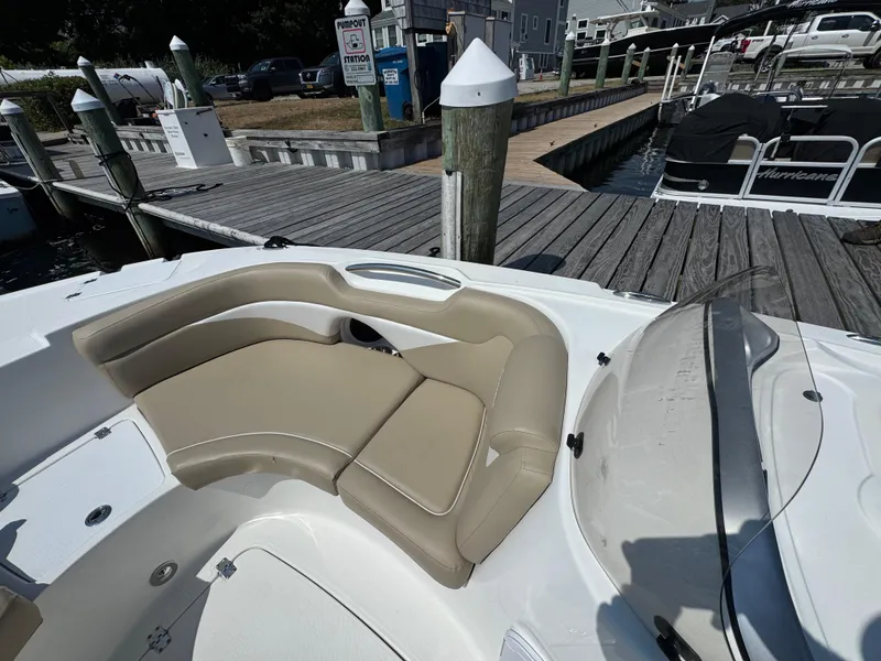 Slide: The Image of 2017 Hurricane SunDeck Sport 203 OB boat interior with beige seating at a dock. - 15