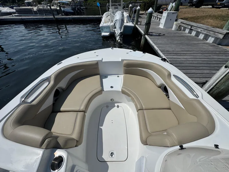 Slide: The Image of 2017 Hurricane SunDeck Sport 203 OB boat with beige seating, docked at a marina. - 18
