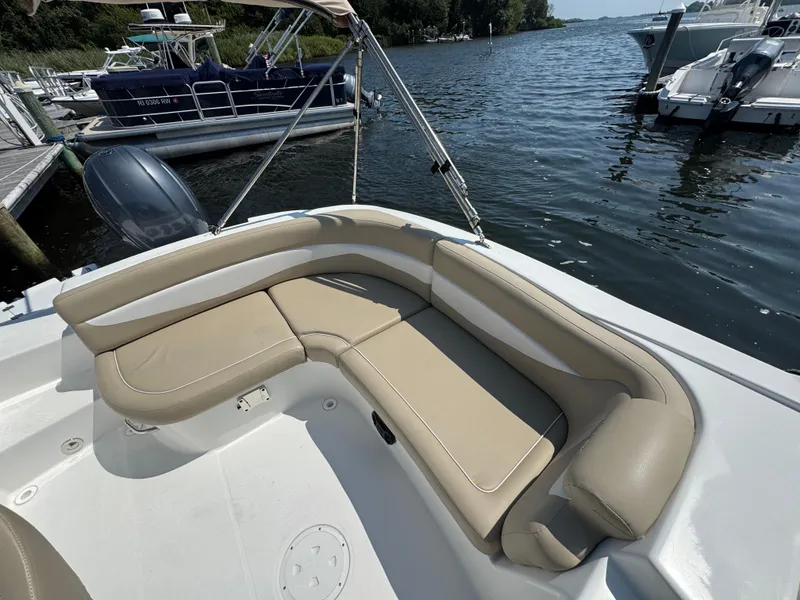 Slide: The Image of 2017 Hurricane SunDeck Sport 203 OB boat with beige seating, docked by the water. - 9