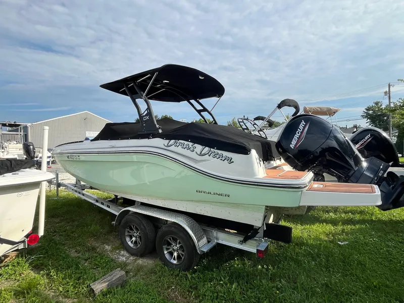 The Image of 2023 Bayliner DX 2000 boat on trailer with Mercury outboard motor. - 1