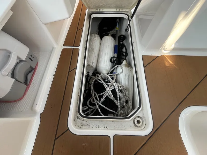 Slide: The Image of Storage compartment on 2023 Bayliner DX 2000 boat with ropes and fenders. - 14