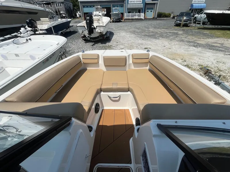 Slide: The Image of 2023 Bayliner DX 2000 boat interior with tan seating, docked at a marina. - 20