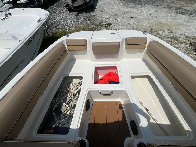 Slide: The Image of 2023 Bayliner DX 2000 boat interior with storage compartments and seating. - 21