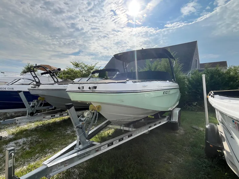 Slide: The Image of 2023 Bayliner DX 2000 boat on trailer under sunny sky. - 4