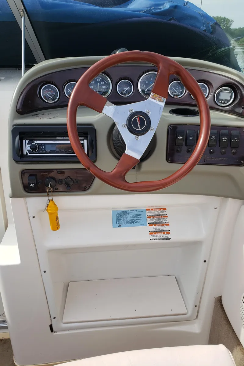 Slide: The Image of 1999 Chaparral 2335 SS boat dashboard with steering wheel and instrument panel. - 11