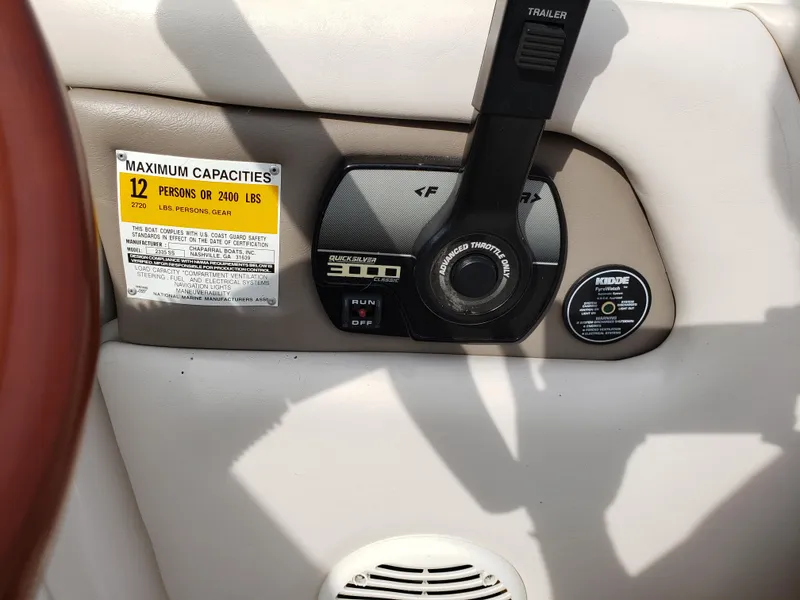 Slide: The Image of 1999 Chaparral 2335 SS boat control panel with capacity label and throttle lever. - 9