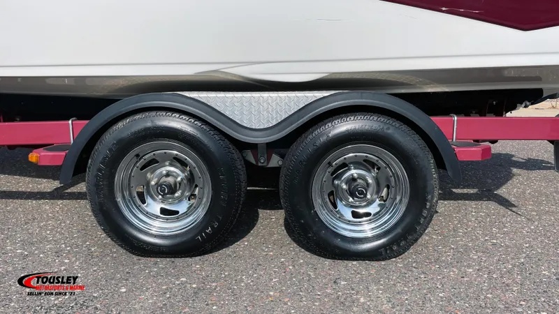 Slide: The Image of 2011 Crownline 21SS boat trailer with dual wheels on asphalt. - 11