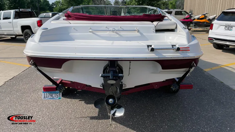 Slide: The Image of 2011 Crownline 21SS boat, rear view, parked in a lot with vehicles nearby. - 3