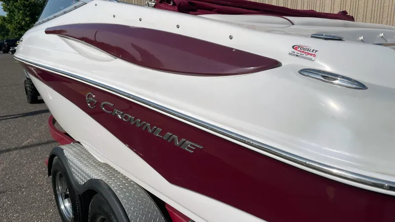 Slide: The Image of 2011 Crownline 21SS boat with maroon and white exterior on a trailer. - 4