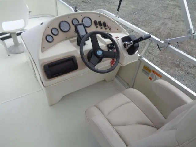 Slide: The Image of 2002 Lowe Suncruiser Trinidad 184 boat dashboard with steering wheel and beige seating. - 20