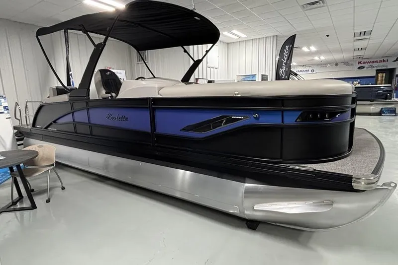 Slide: The Image of 2026 Barletta Corsa pontoon boat displayed indoors with sleek design and modern features. - 2
