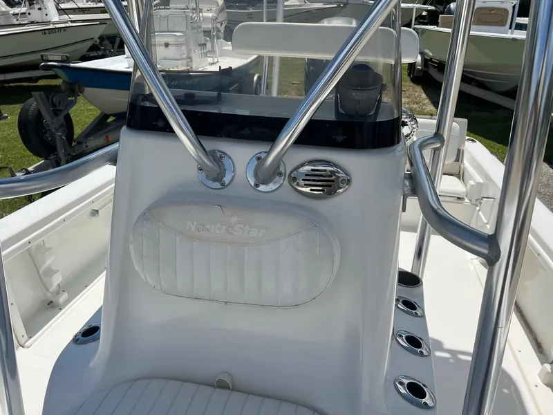 Slide: The Image of 2011 NauticStar 2200 Tournament boat console with stainless steel railings and cup holders. - 11