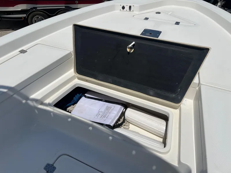 Slide: The Image of Open storage compartment on 2011 NauticStar 2200 Tournament boat, containing ropes and documents. - 19