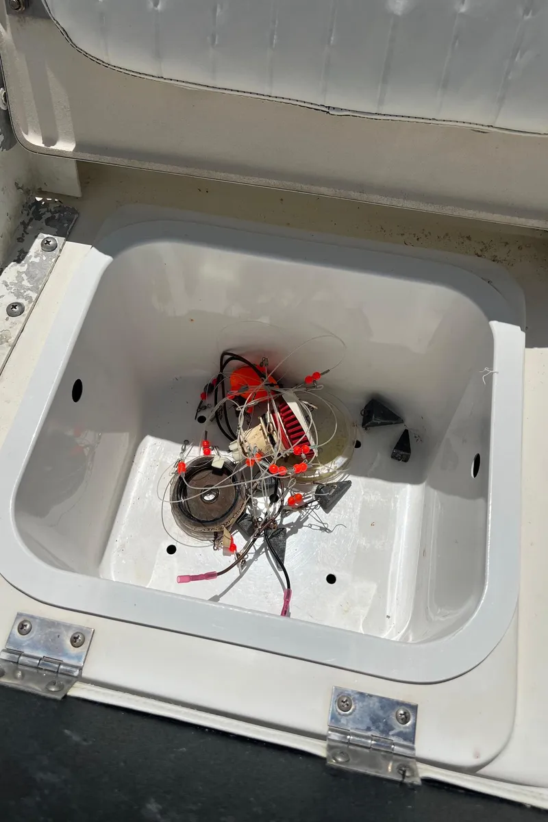 Slide: The Image of Open compartment of 2011 NauticStar 2200 Tournament boat with wires and debris inside. - 23