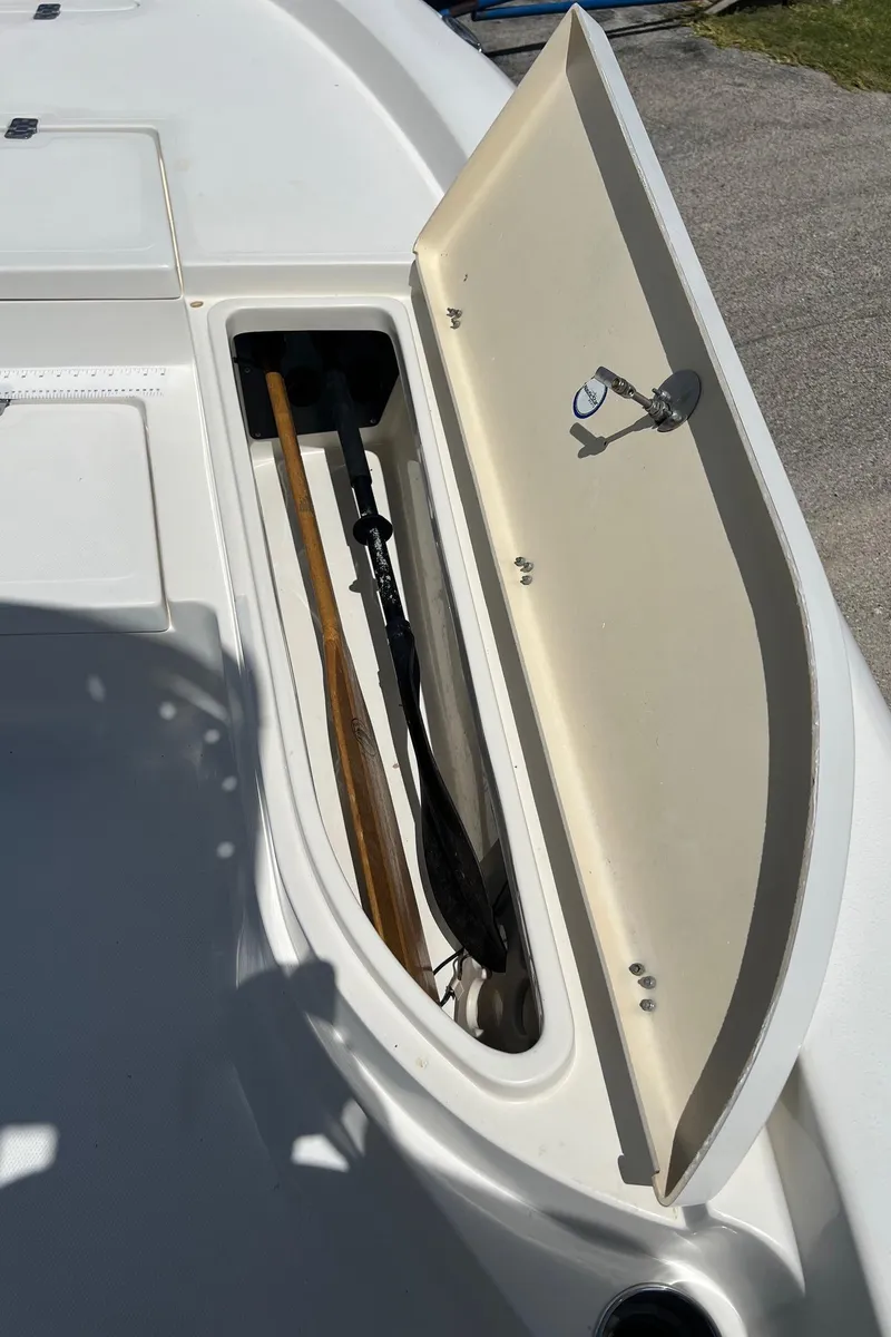 Slide: The Image of Open storage compartment on 2011 NauticStar 2200 Tournament boat, showing fishing gear. - 25