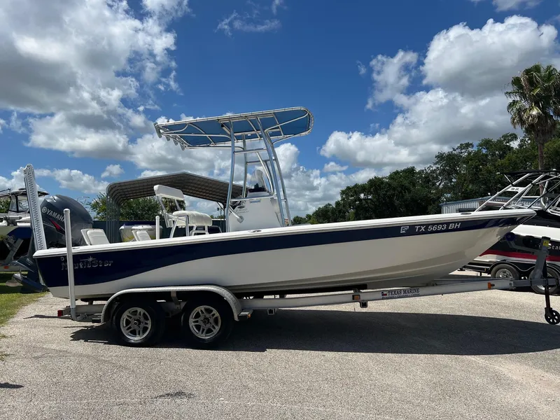 Slide: The Image of 2011 NauticStar 2200 Tournament boat on trailer under blue sky. - 5