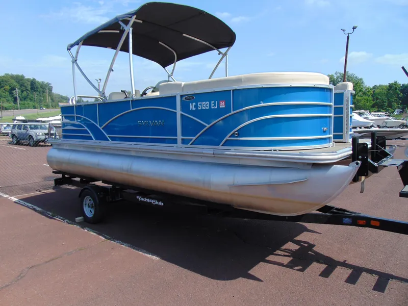 Slide: The Image of 2019 Sylvan Mirage 820 Cruise pontoon boat on trailer, blue exterior, parked outdoors. - 4