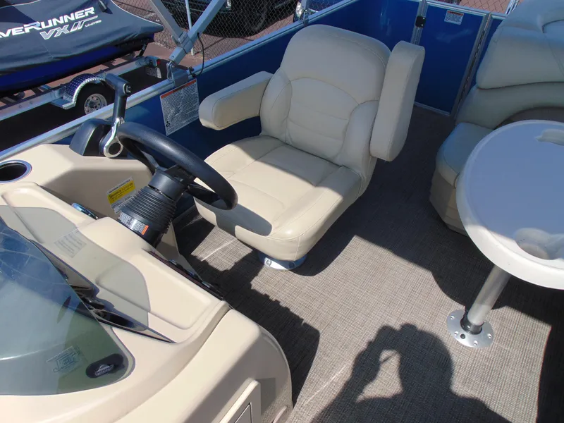 Slide: The Image of 2019 Sylvan Mirage 820 Cruise boat interior with beige captain's chair and steering wheel. - 9