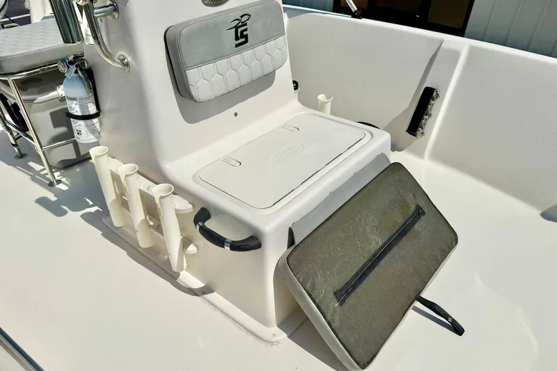 Slide: The Image of 2025 Carolina Skiff EV180 Sea Skiff interior with storage compartment and rod holders. - 13