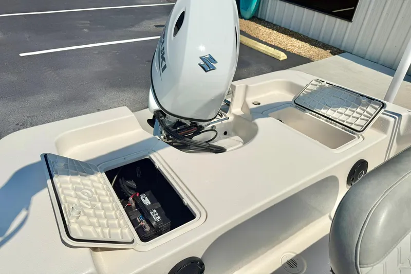 Slide: The Image of 2025 Carolina Skiff EV180 Sea Skiff with open storage compartments and outboard motor. - 21