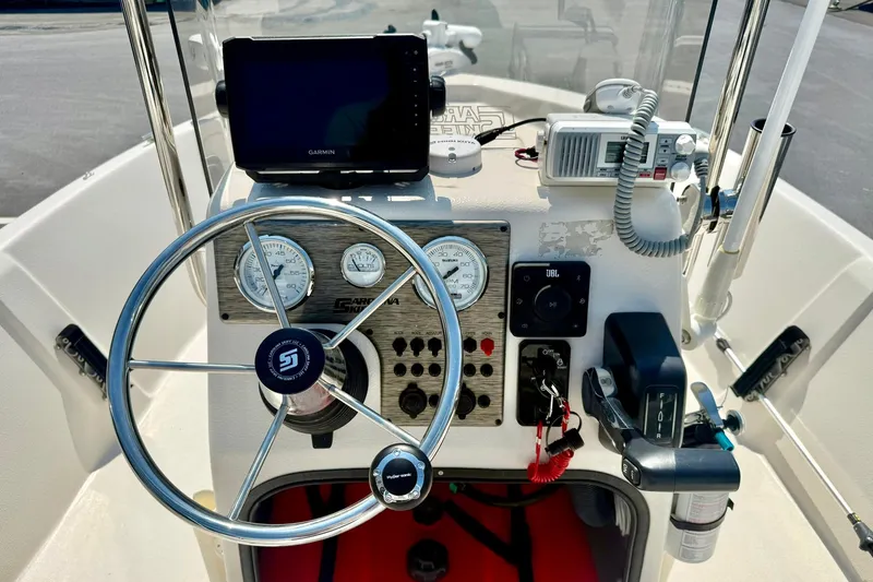Slide: The Image of 2025 Carolina Skiff EV180 Sea Skiff dashboard with steering wheel, gauges, and navigation equipment. - 3