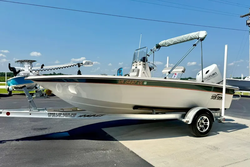 Slide: The Image of 2025 Carolina Skiff EV180 Sea Skiff on trailer, parked outdoors under clear sky. - 5