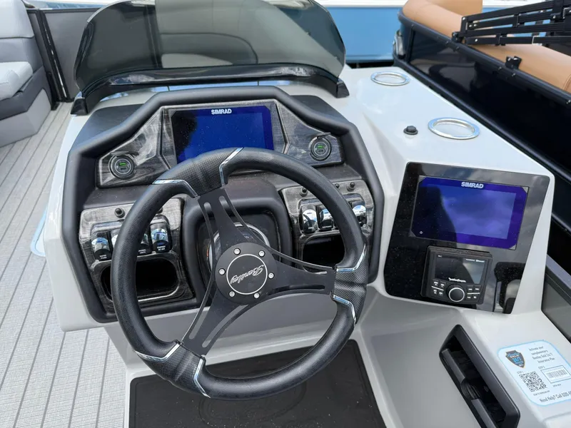 Slide: The Image of 2026 Bentley Pontoons Elite 253 Swingback dashboard with steering wheel and Simrad displays. - 6