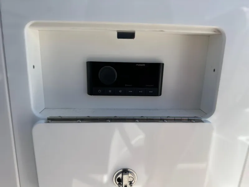 Slide: The Image of 2024 Monterey M-65 boat audio system compartment with Fusion stereo controls. - 16