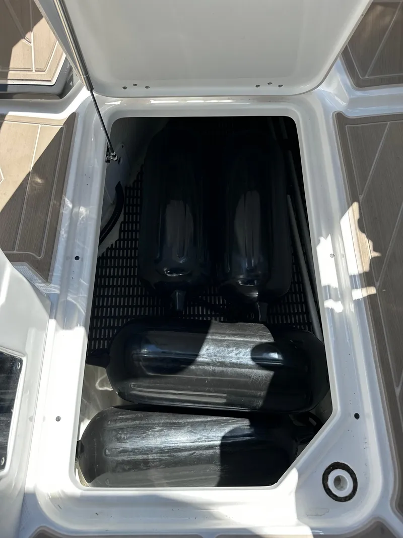 Slide: The Image of Storage compartment of 2024 Monterey M-65 boat with black fenders inside. - 21