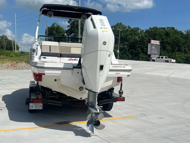 Slide: The Image of 2024 Monterey M-65 boat on trailer, featuring powerful outboard motor, parked in sunny lot. - 23