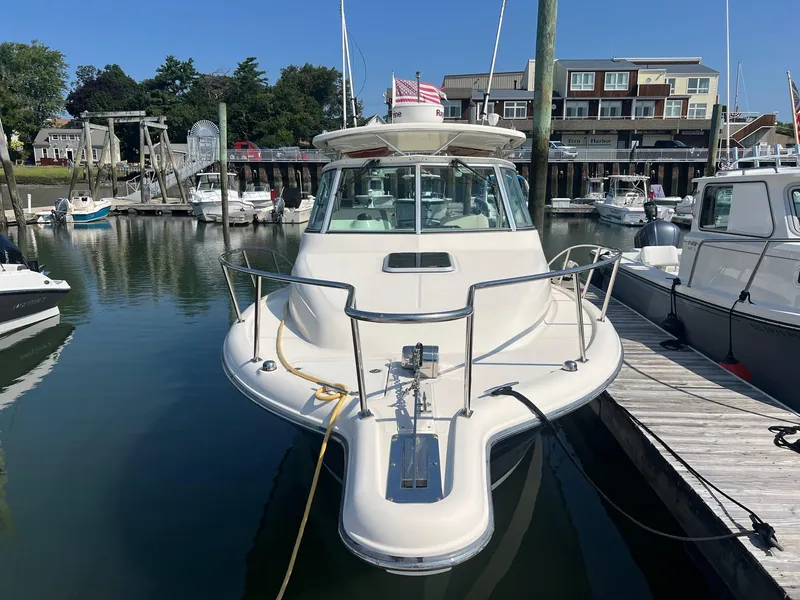 The Image of 2007 Pursuit OS 285 Offshore boat docked in a marina, surrounded by other vessels. - 0
